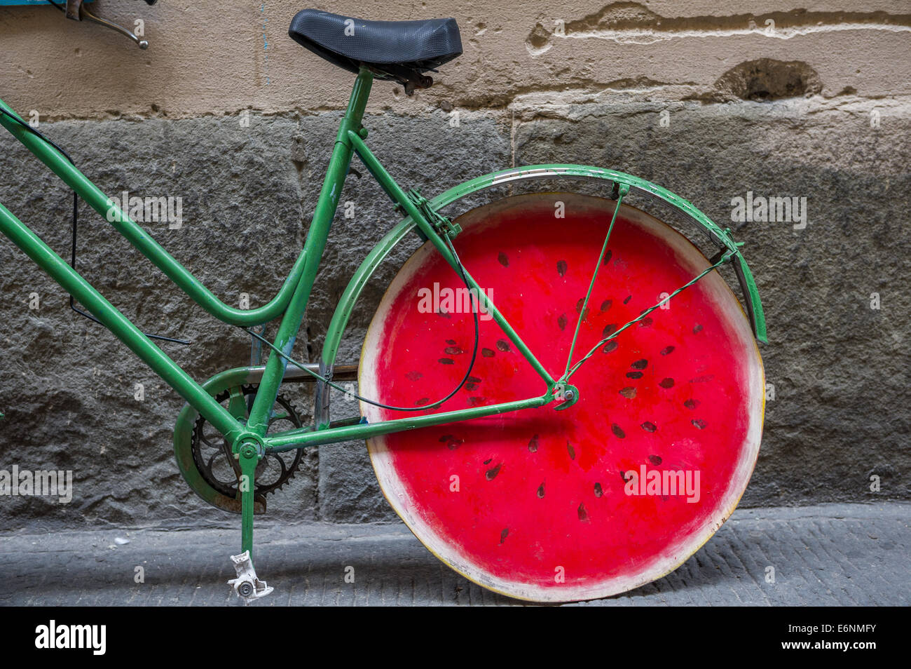 Green cycle with red coloured wooden wheels in the form of a water melon. Stock Photo