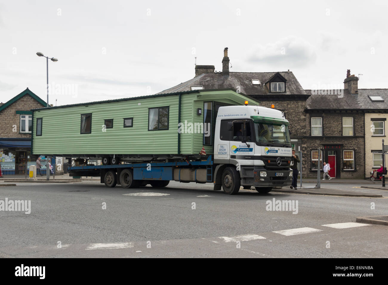 Kendal Caravans Mercedes Actros 1836 flatbed lorry transporting a static caravan with a long rear overhang in Kendal, Cumbria Stock Photo