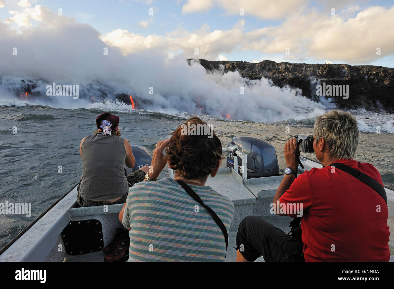 People photographing lava flowing to the sea from a boat, Kilauea Volcano, Big Island, Hawaii Volcanoes National Park Stock Photo