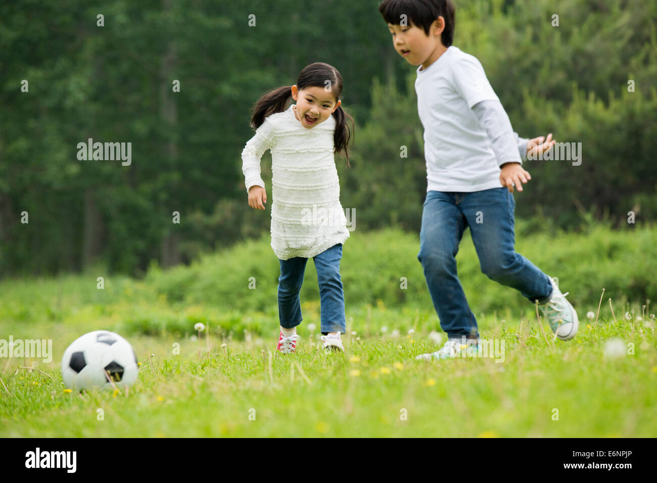 Happy children playing football together Stock Photo - Alamy