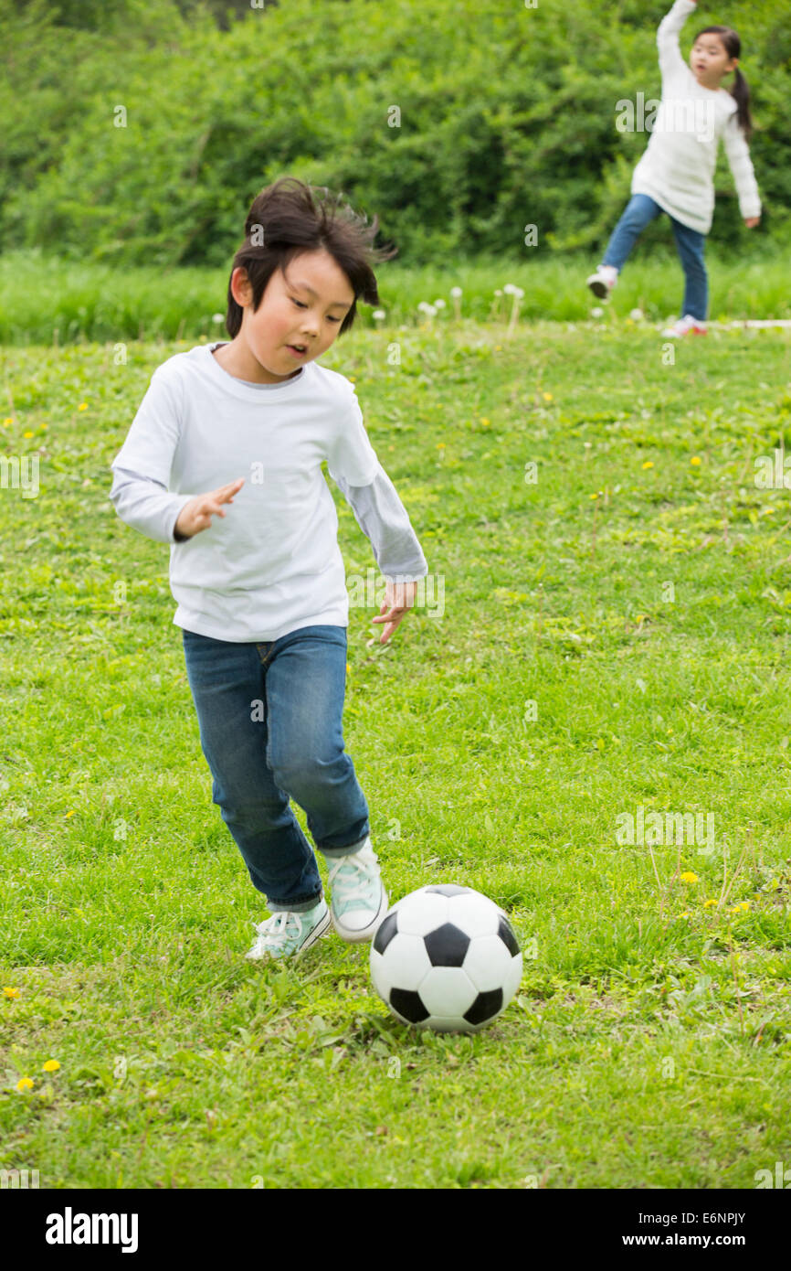 Happy children playing football together Stock Photo - Alamy