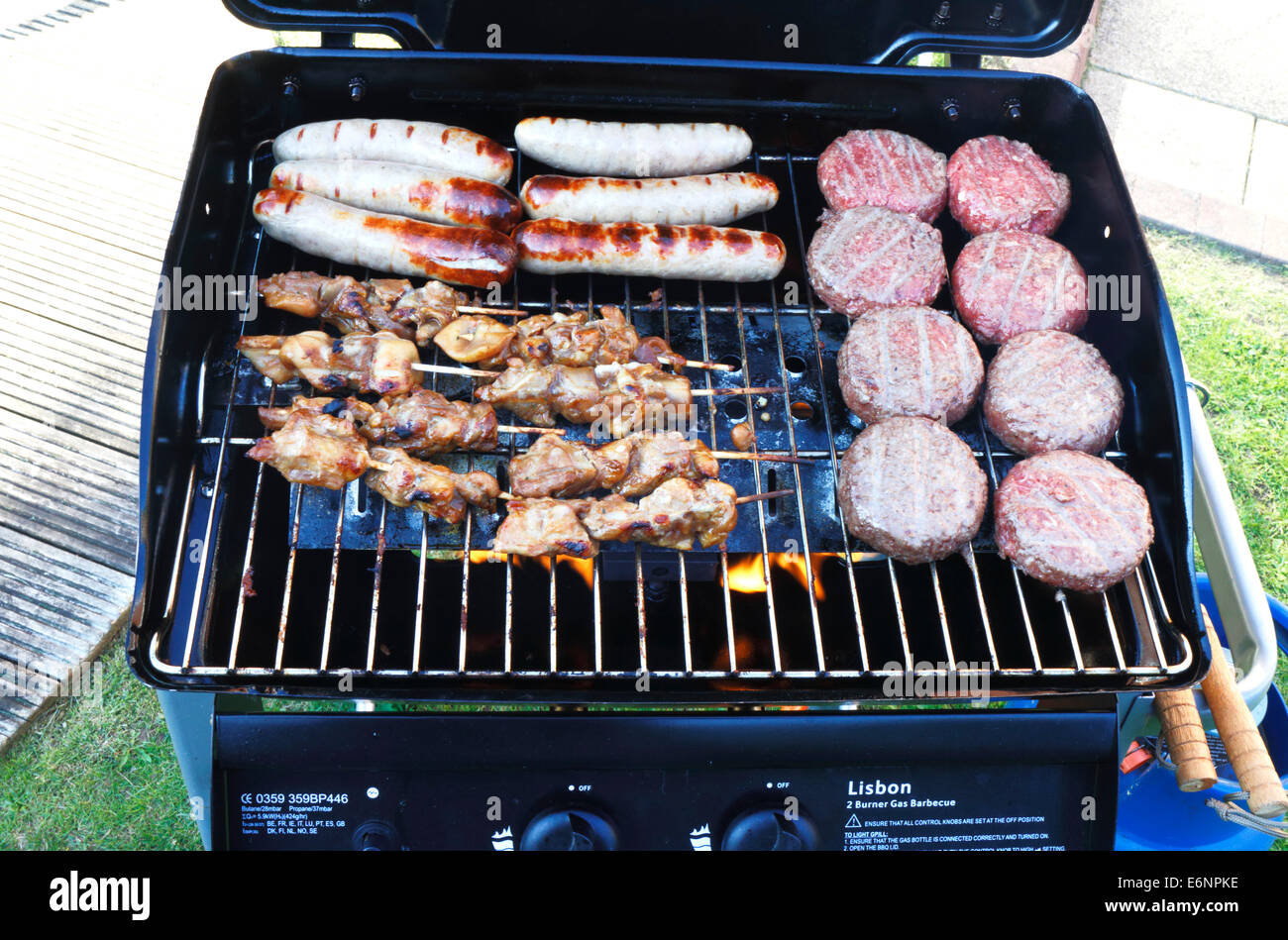 A gas burner BBQ loaded with fresh food in the process of cooking Stock