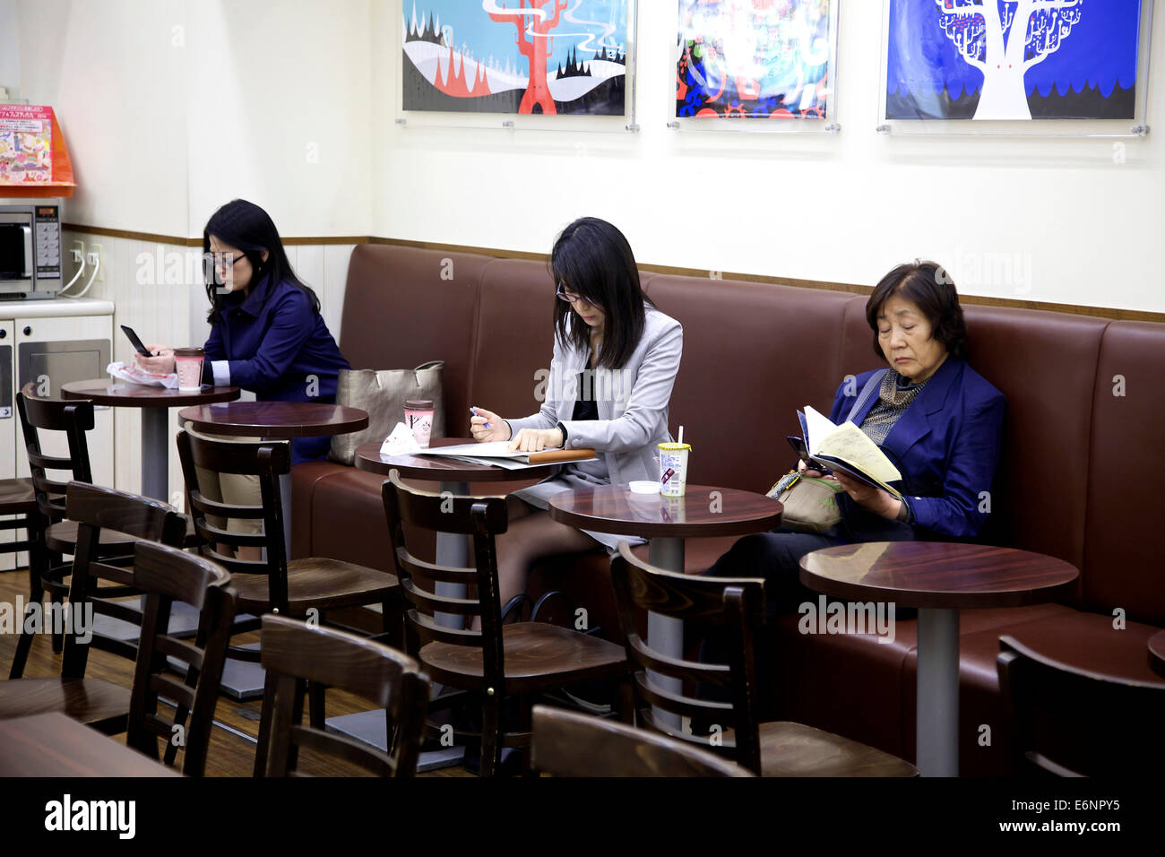 Female manager, young businesswoman, japanese business woman working in bar, old lady reading book. Tokyo, Japan, Asia Stock Photo