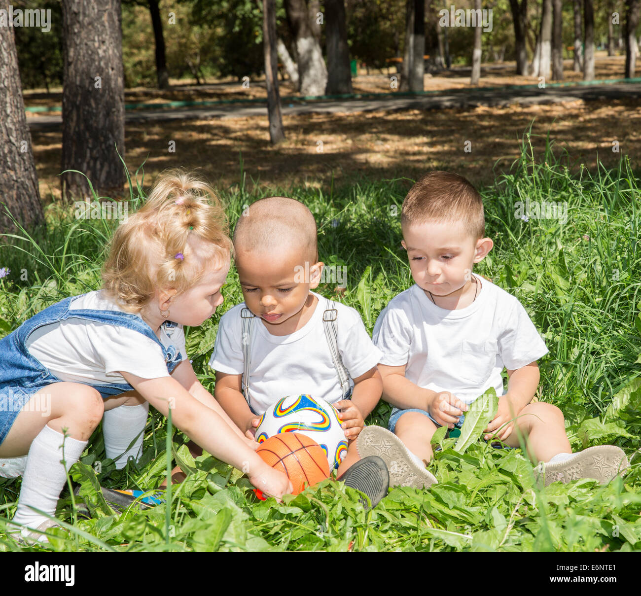 Group of happy children playing with soccer ball in park on nature at ...