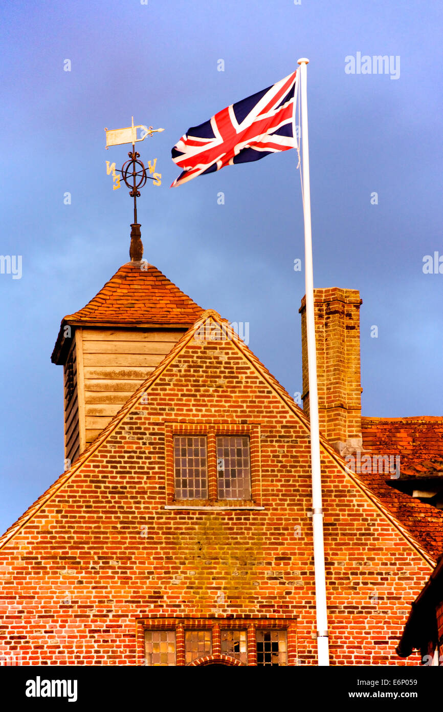 The Union Jack waving over typical English brick buildings. A symbol of traditional 'Merry Old England'. Stock Photo