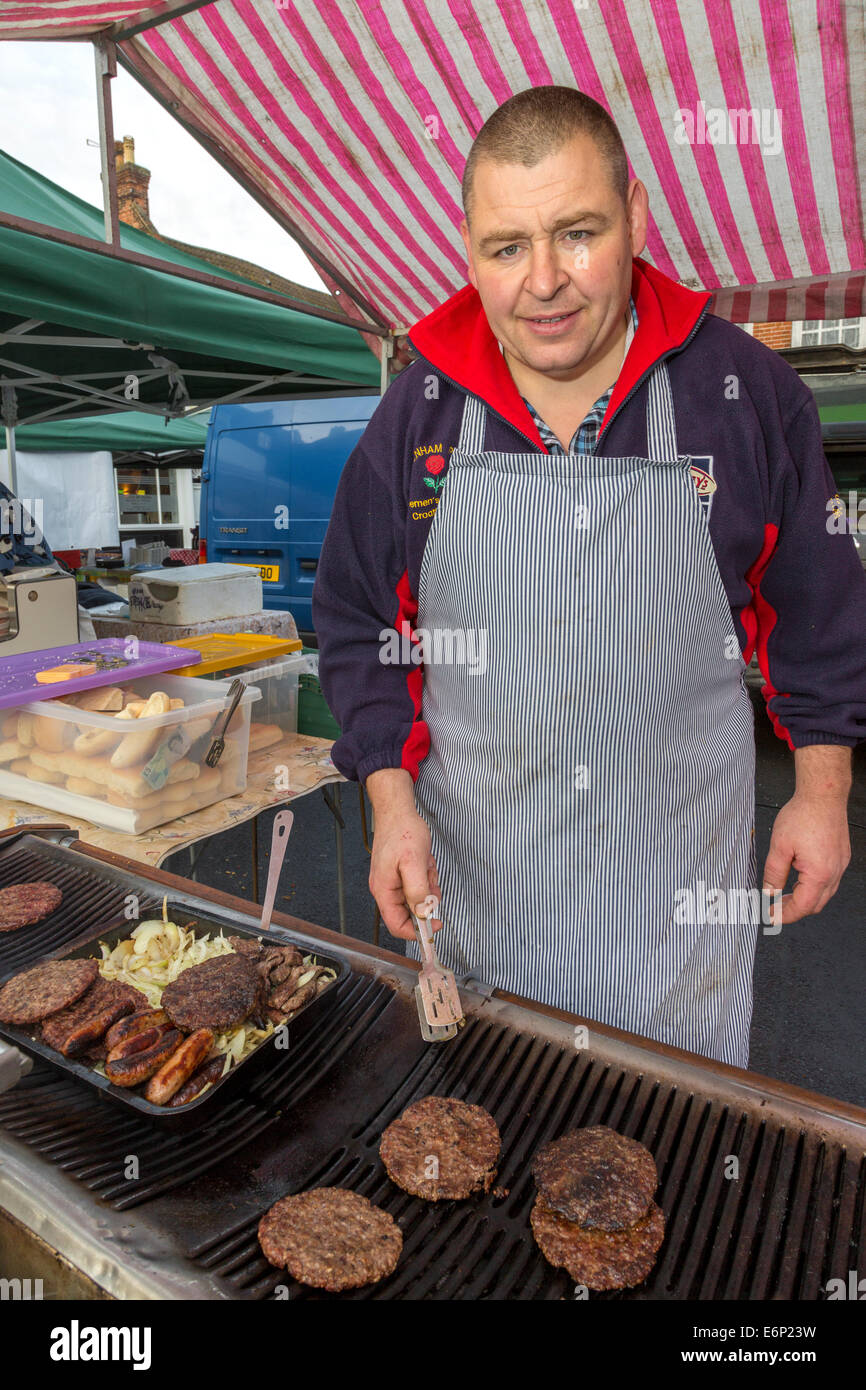 Market stall holder selling beefburgers and sausages, farmers market