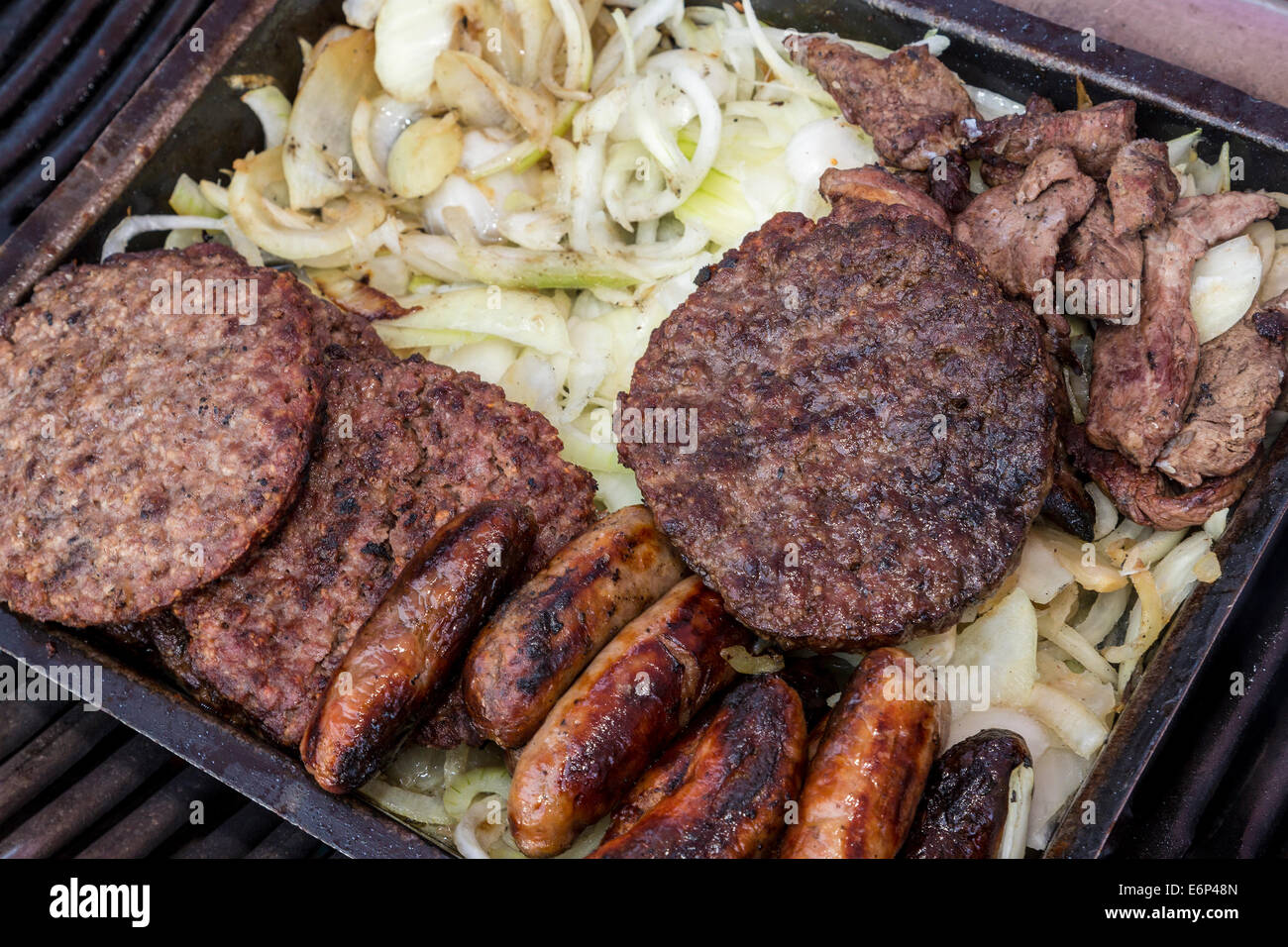 Griddle of beef burgers, sausages, bacon and onions Stock Photo Alamy