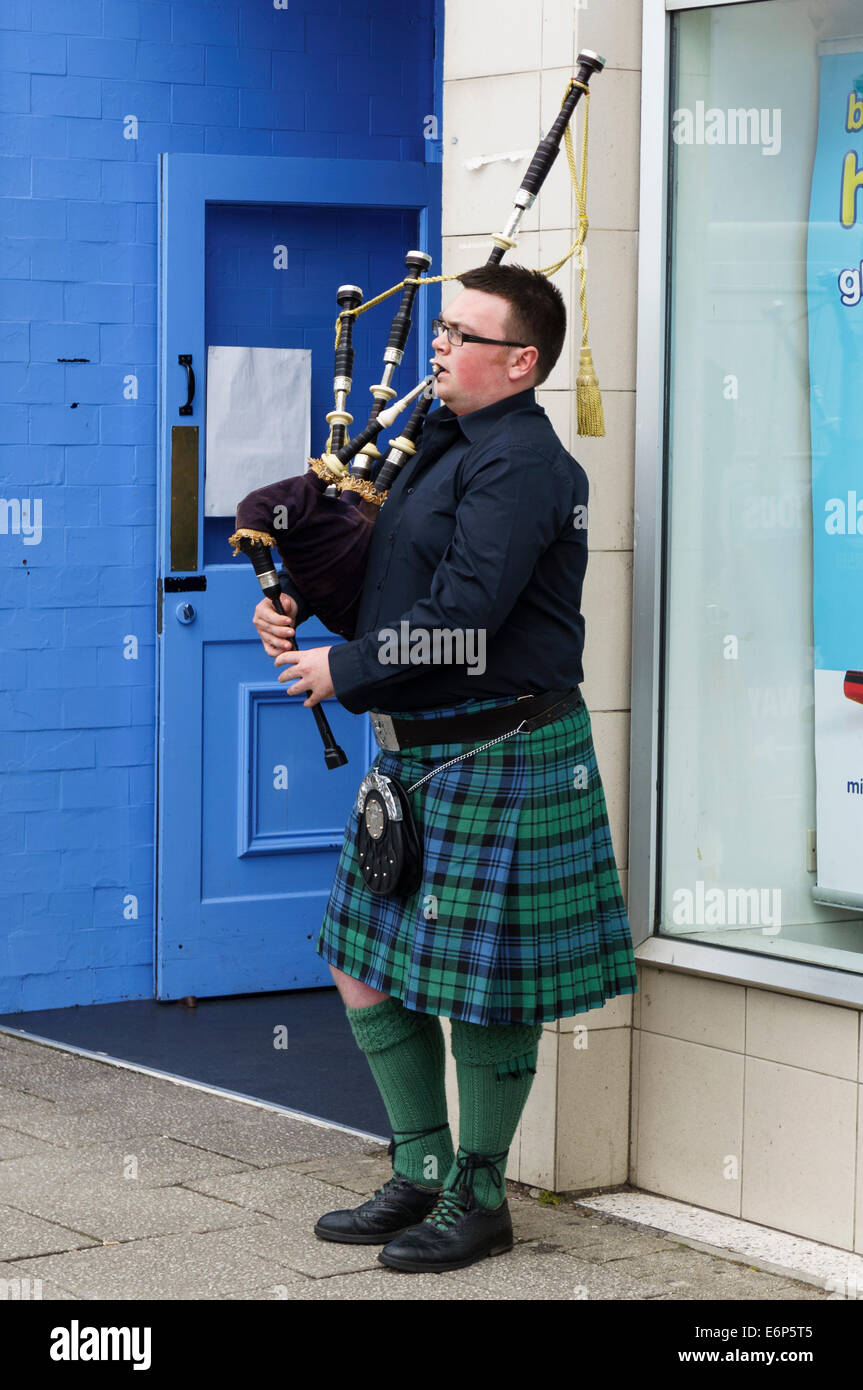 Male scottish bagpipe player wearing kilt outside Skipinnish Ceilidh House, Oban, Argyll & Bute, Scotland, UK. Skipinnish Ceilidh House is a Scottish traditional music venue in Oban.  Model Release: No.  Property Release: No. Stock Photo