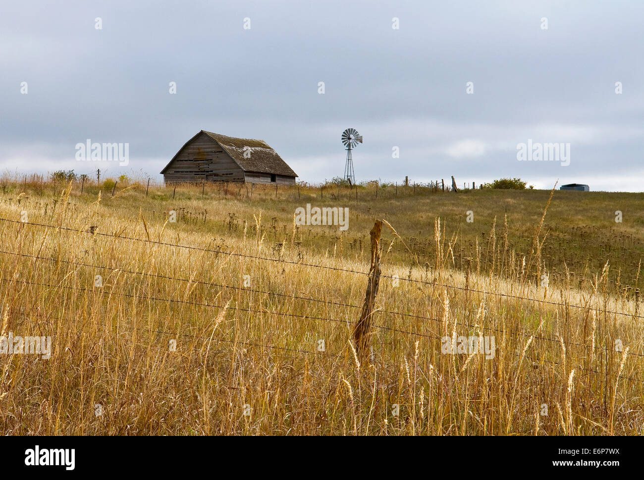 USA, Kansas. Old Barn with Windmill on hill Stock Photo