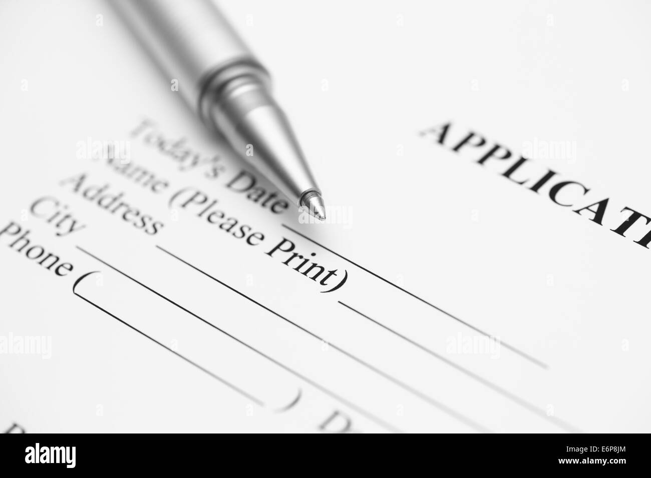 Application form and ballpoint pen. Focus on the end of ballpoint pen. Black and White. Stock Photo