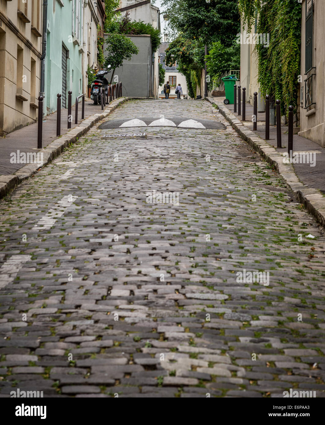 Two men reach the top of a hill on a cobble stone street in Paris France. Stock Photo
