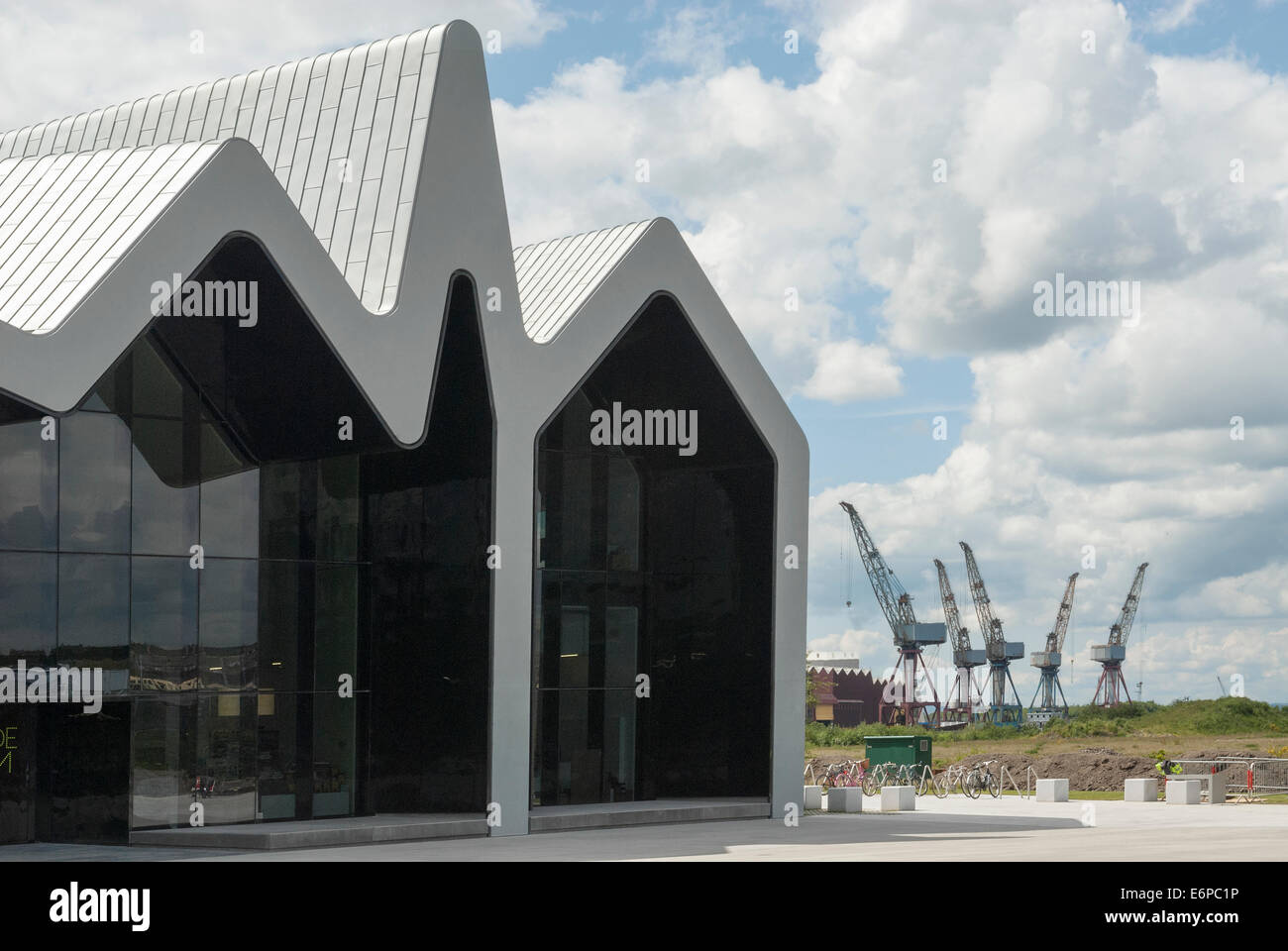 Glasgow Riverside Museum of Transport with Shipyard cranes in the background.. Stock Photo
