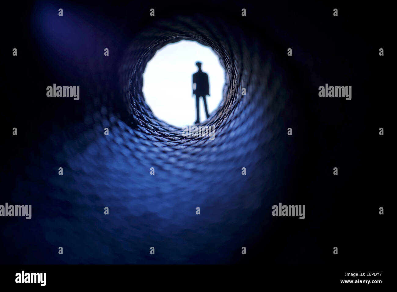 silhouette of a man looking into a dark tunnel Stock Photo