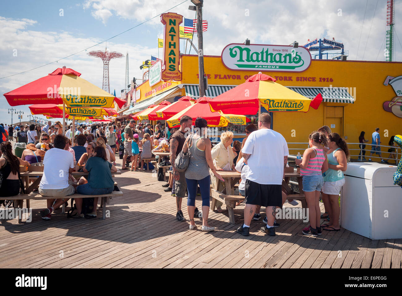 Visitors to Coney Island in New York on Sunday, August 24, 2014 stop at the Nathan's Famous restaurant branch on the boardwalk. Stock Photo