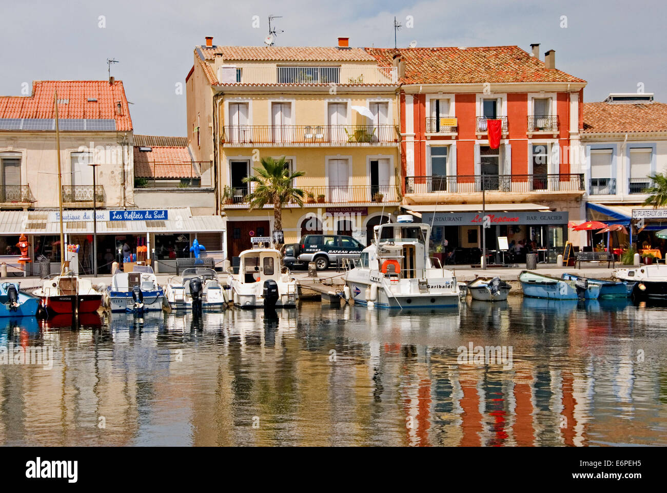 Buildings and boats reflected in the harbour at Meze, in the French town of Meze. Stock Photo