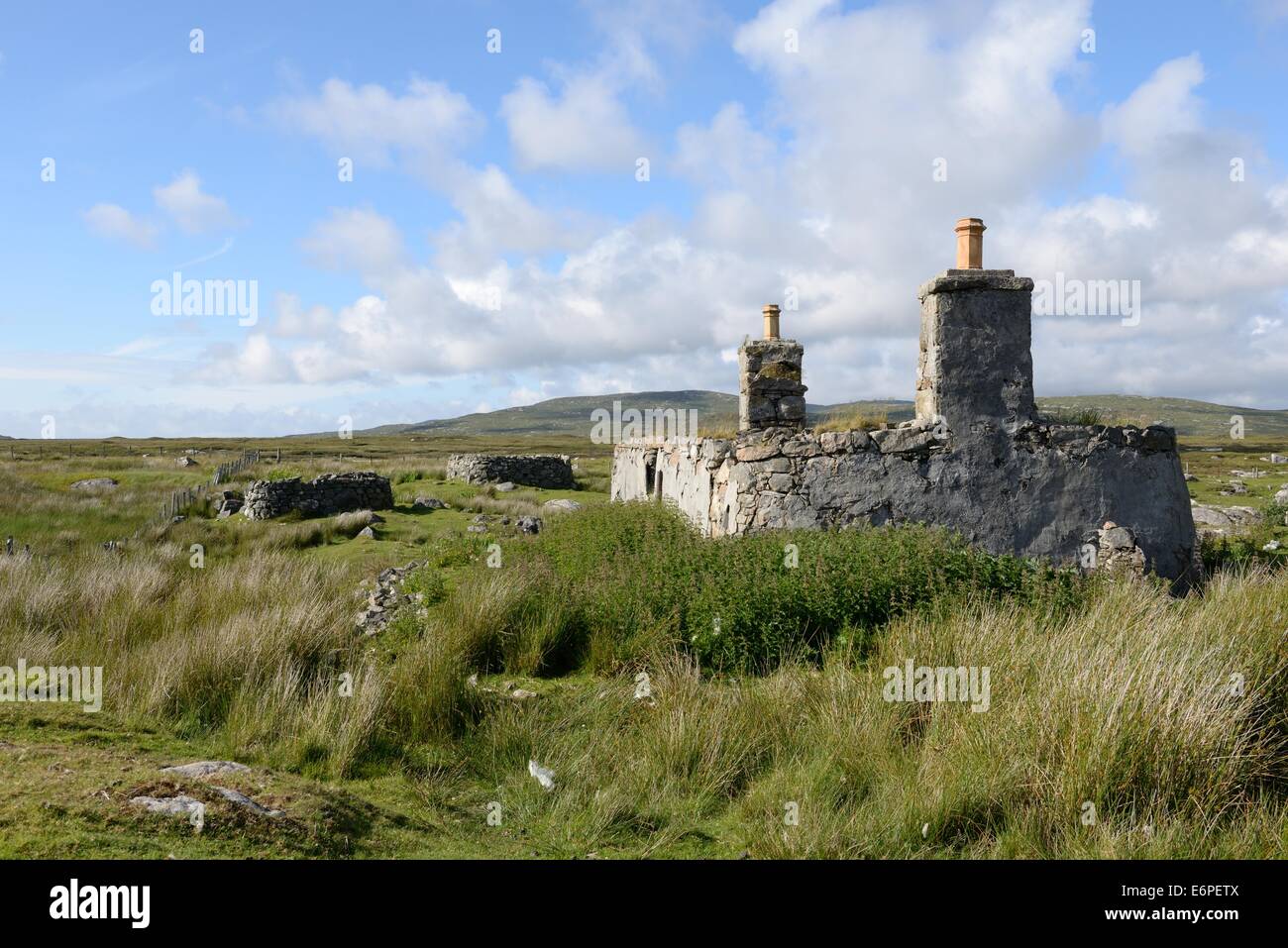 Round cornered stone house ruins on the rough terrain of the Scottish Outer Hebrides Stock Photo