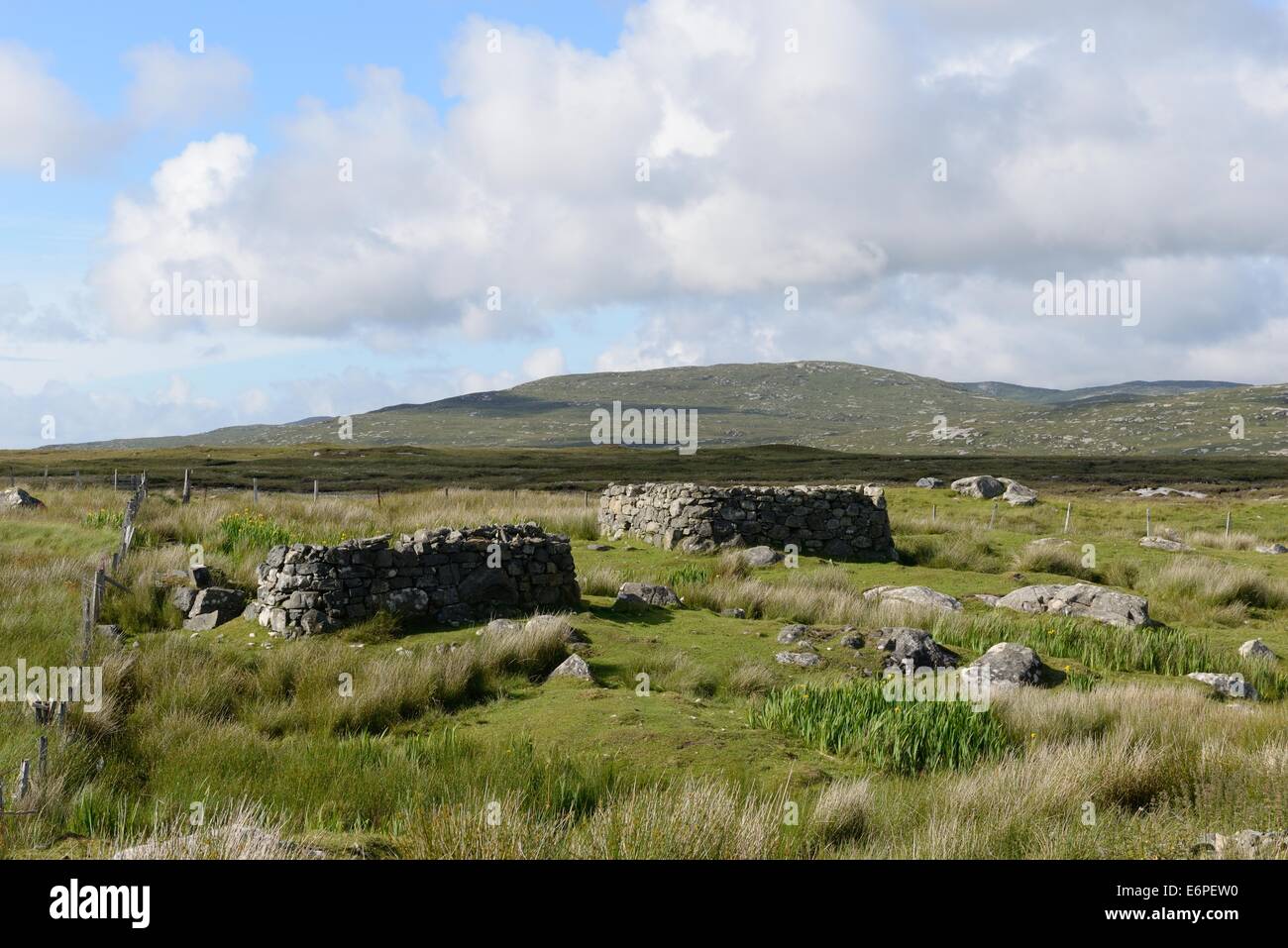 Two round cornered stone house ruins on the rough terrain of the Scottish Outer Hebrides Stock Photo