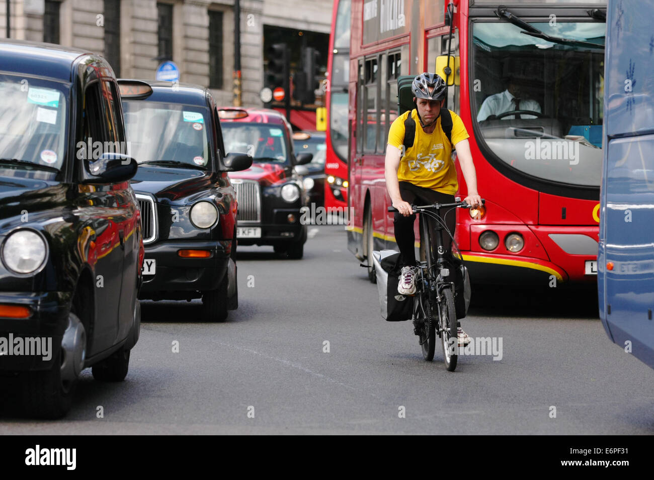 A cyclist cycling in busy traffic in London Stock Photo - Alamy