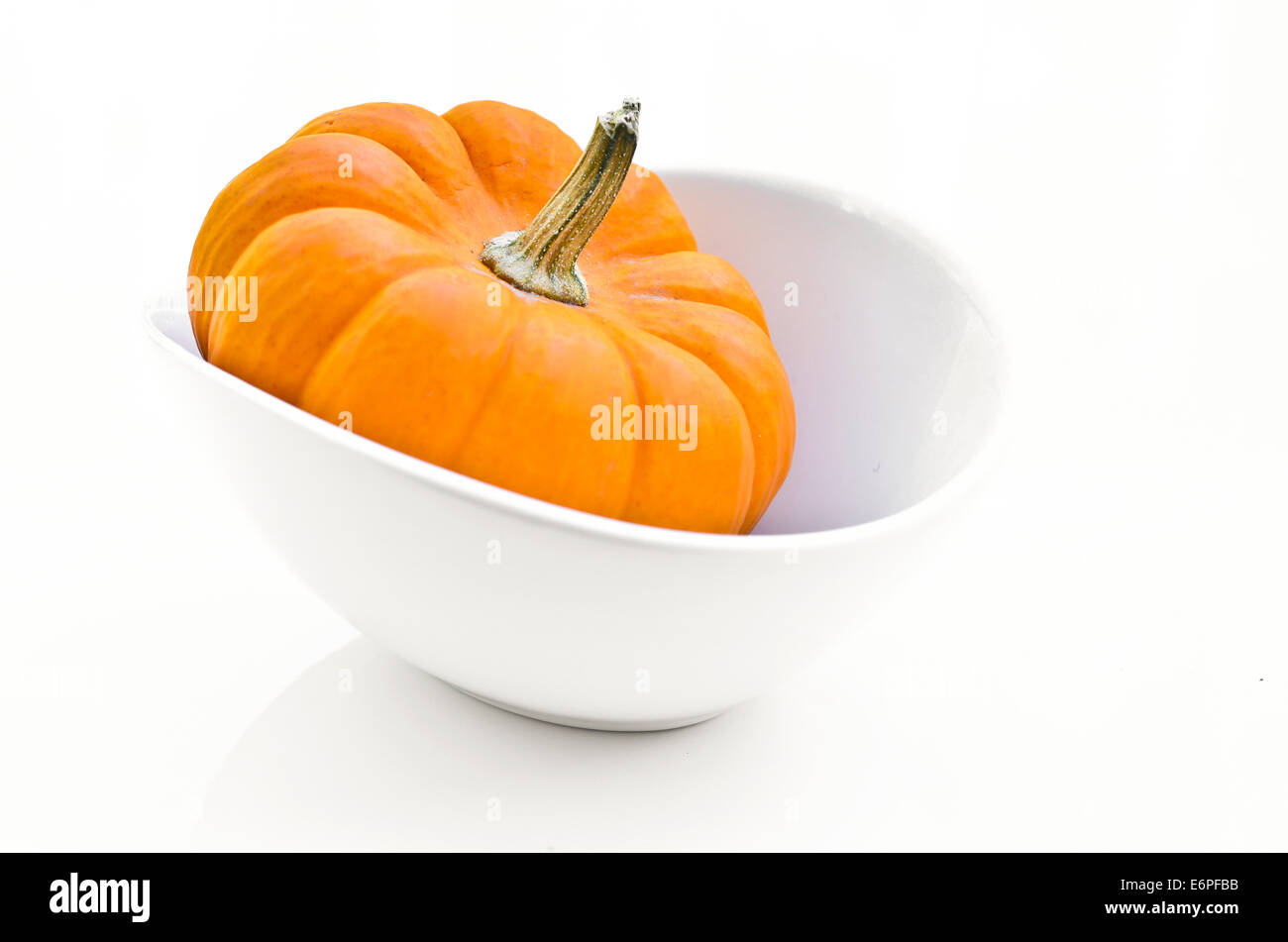 Small pumpkin in a white bowl on white background Stock Photo