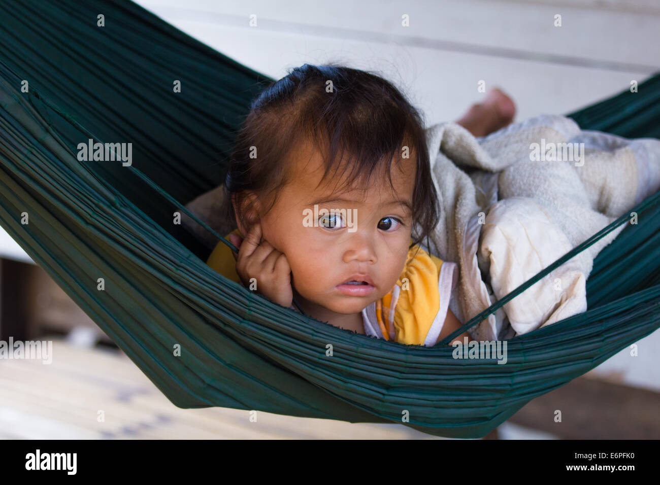 Young Cambodian girl in a hammock at the floating village of Chong Kos, near Kampong Chhnang, Cambodia Stock Photo