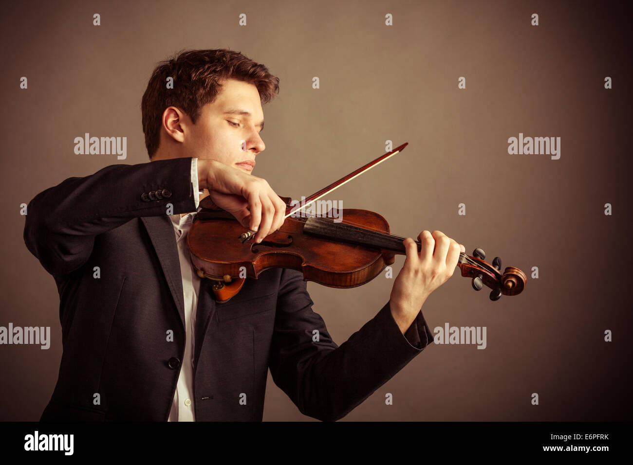 Art and artist. Young elegant man violinist fiddler playing violin on