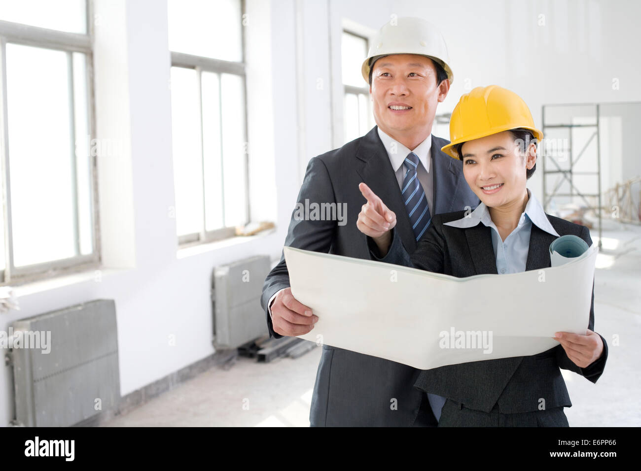 Two colleagues discussing a blueprint Stock Photo