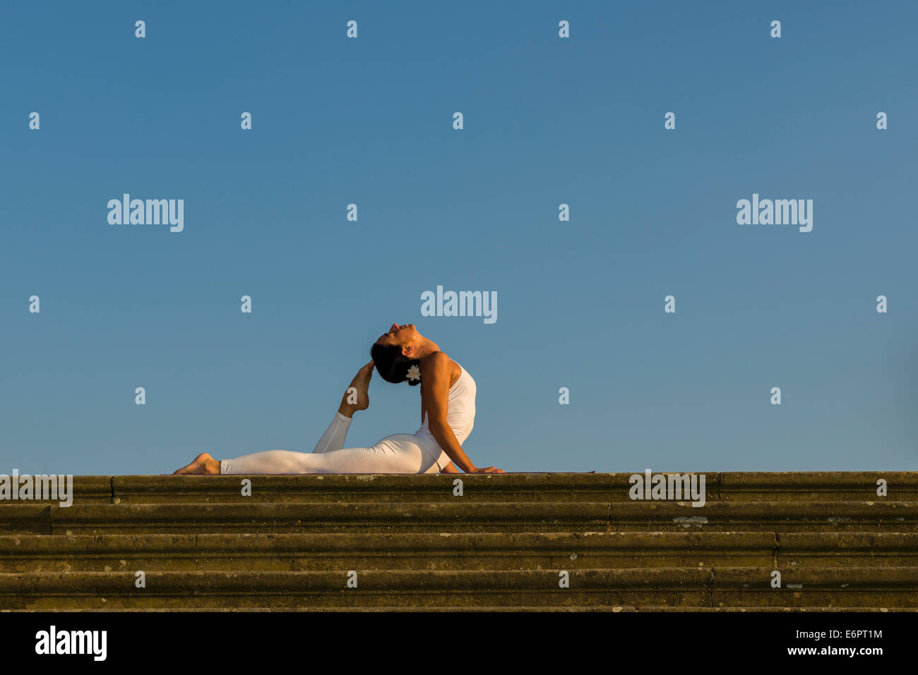 Young woman practising Hatha yoga, outdoors, showing the pose ...