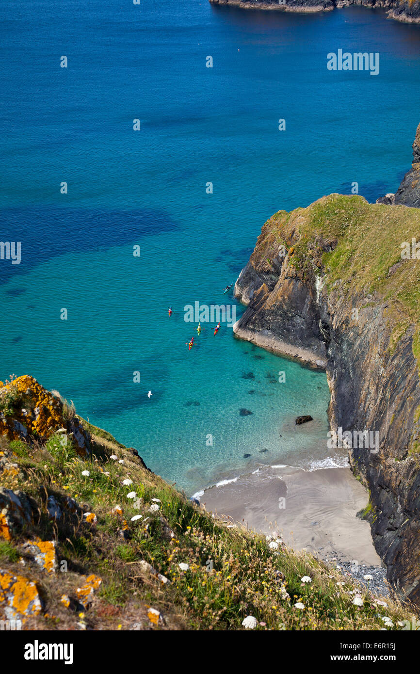 Sea kayakers in the secluded coves and clear waters near Mullion Cove on the Lizard Peninsula, Cornwall, England, UK Stock Photo
