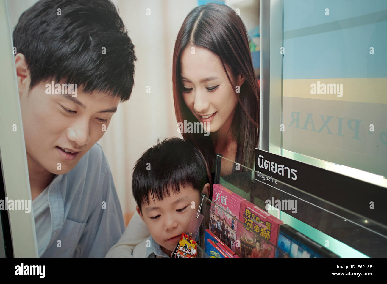 Advertising poster in Bangkok Thailand showing airbrushed faces of woman and boy Stock Photo