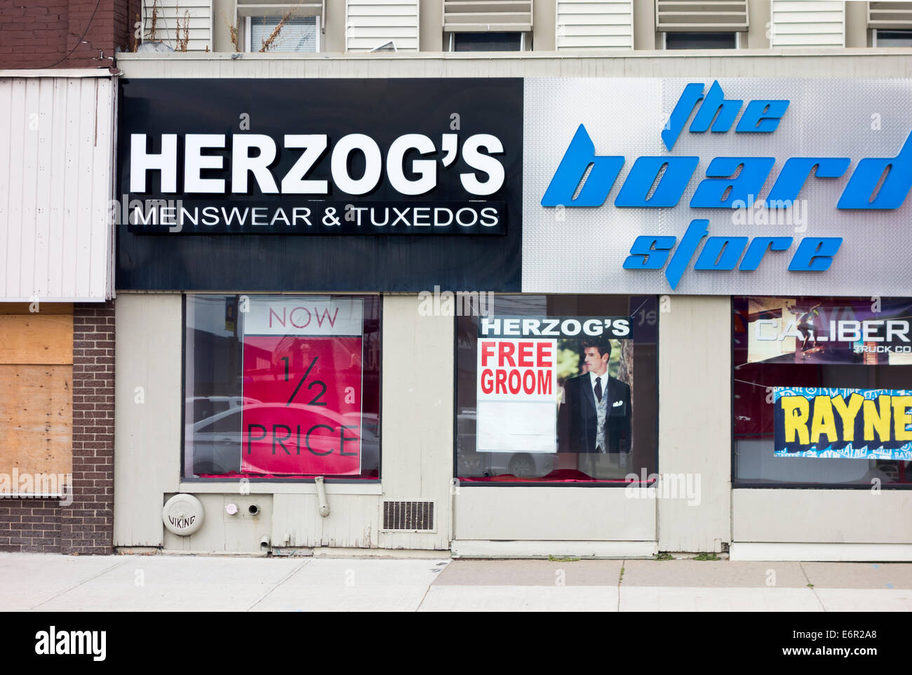 Men's clothing store, with a sign advertising a Free Groom.  Herzog's menswear store in St Catharines, Ontario Canada. Stock Photo