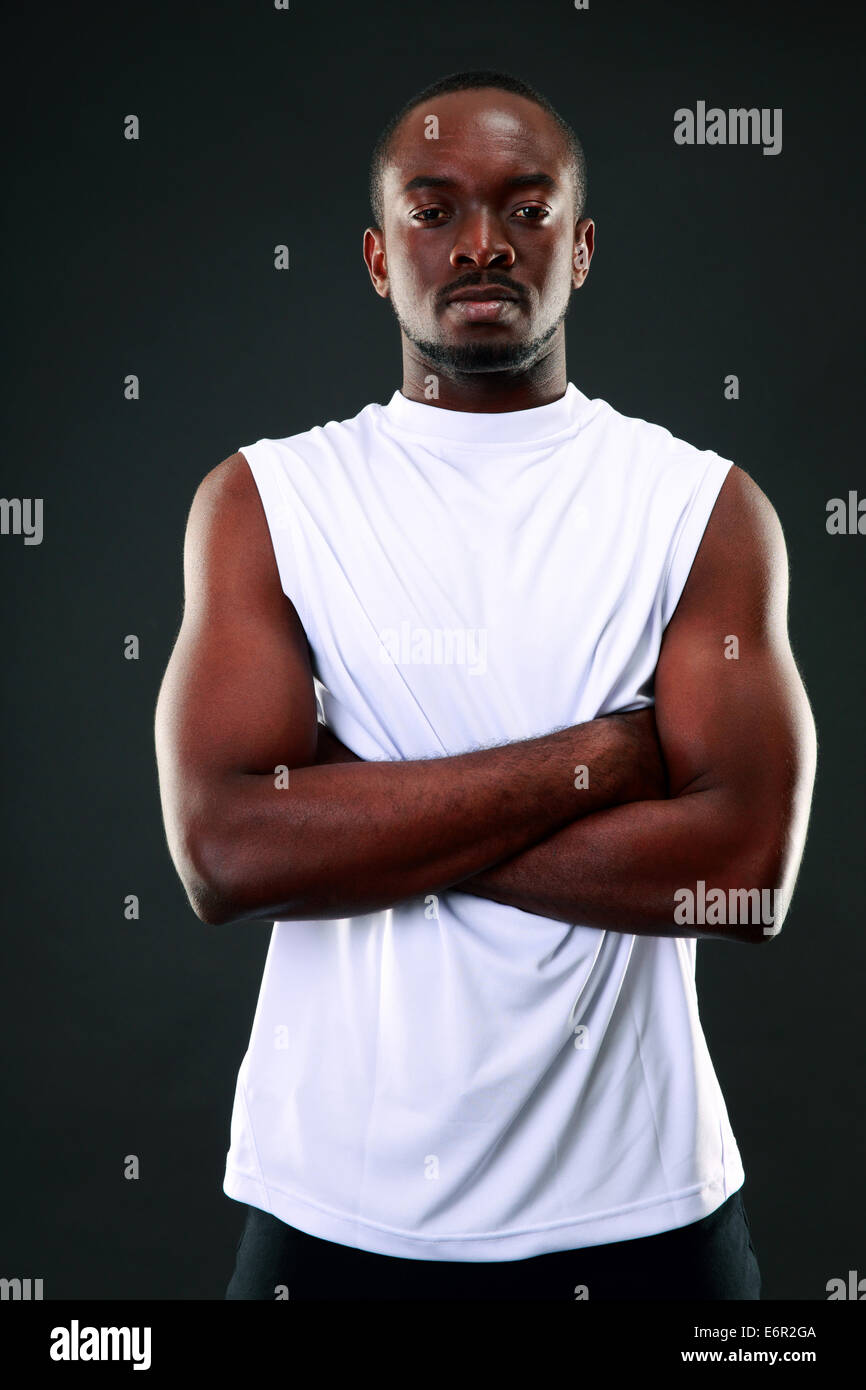 Portrait of a thoughtful african man with arms folded over black ...