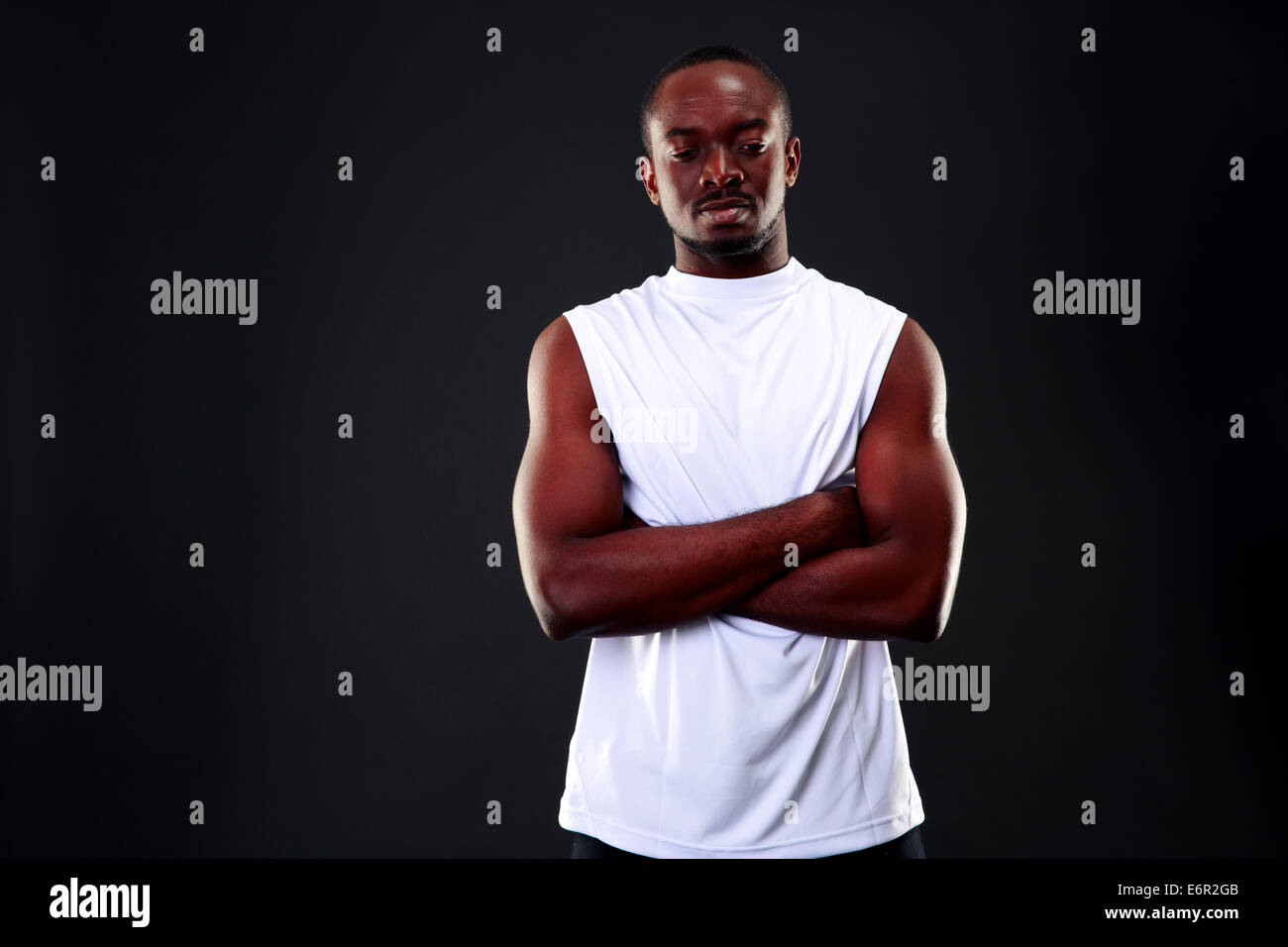 Portrait of a pensive african man with arms folded over black ...