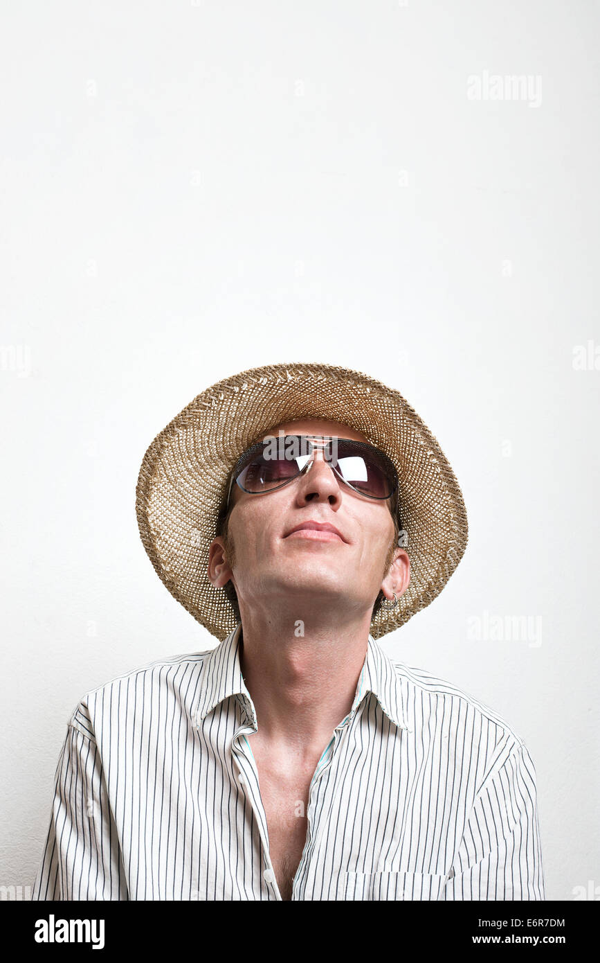 Young man in straw hat and sunglasses look up. Stock Photo