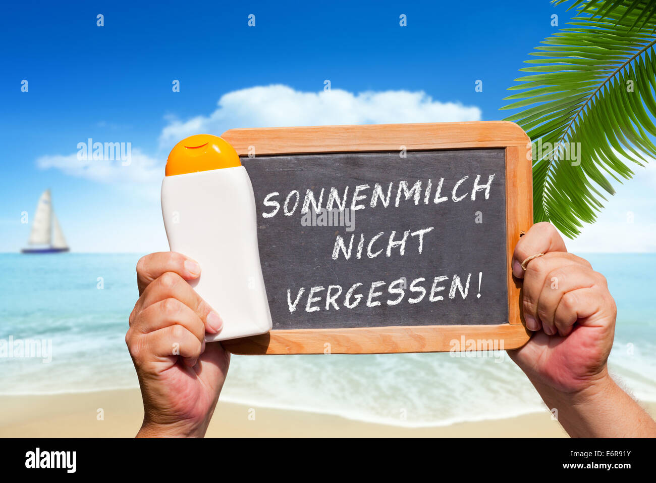 Human Hands hold a bottle sunscreen and a slate blackboard with text message 'Sonnenmilch nicht vergessen'(Don´t forget to wear Stock Photo