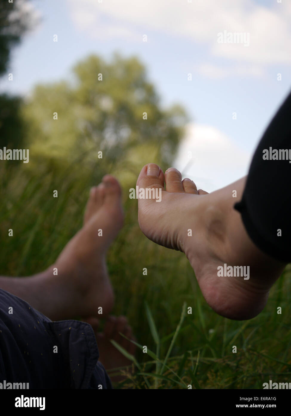 Two people's feet, taken lying in the grass on a Summer day Stock Photo