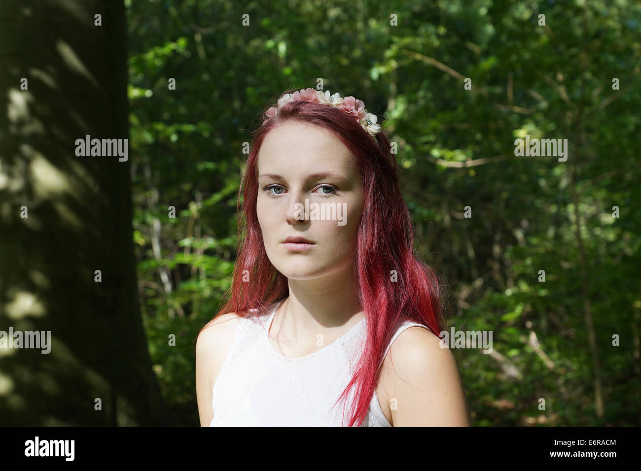 young woman with flowers in her hair in a forest Stock Photo