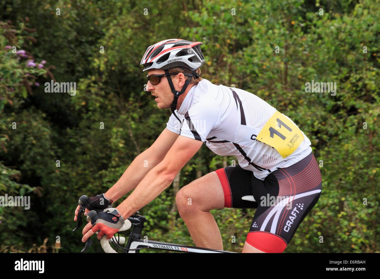 A Millennial man wearing Lycra and a cycle helmet racing in a local bike race organised by British Cycling. England UK Britain Stock Photo