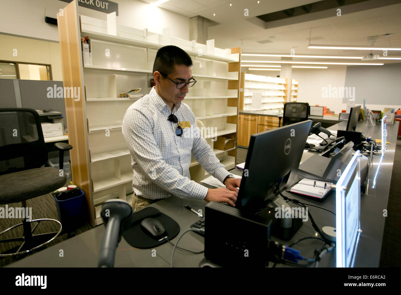 Hispanic Male Librarian Checks Computer Inside Library Of The New
