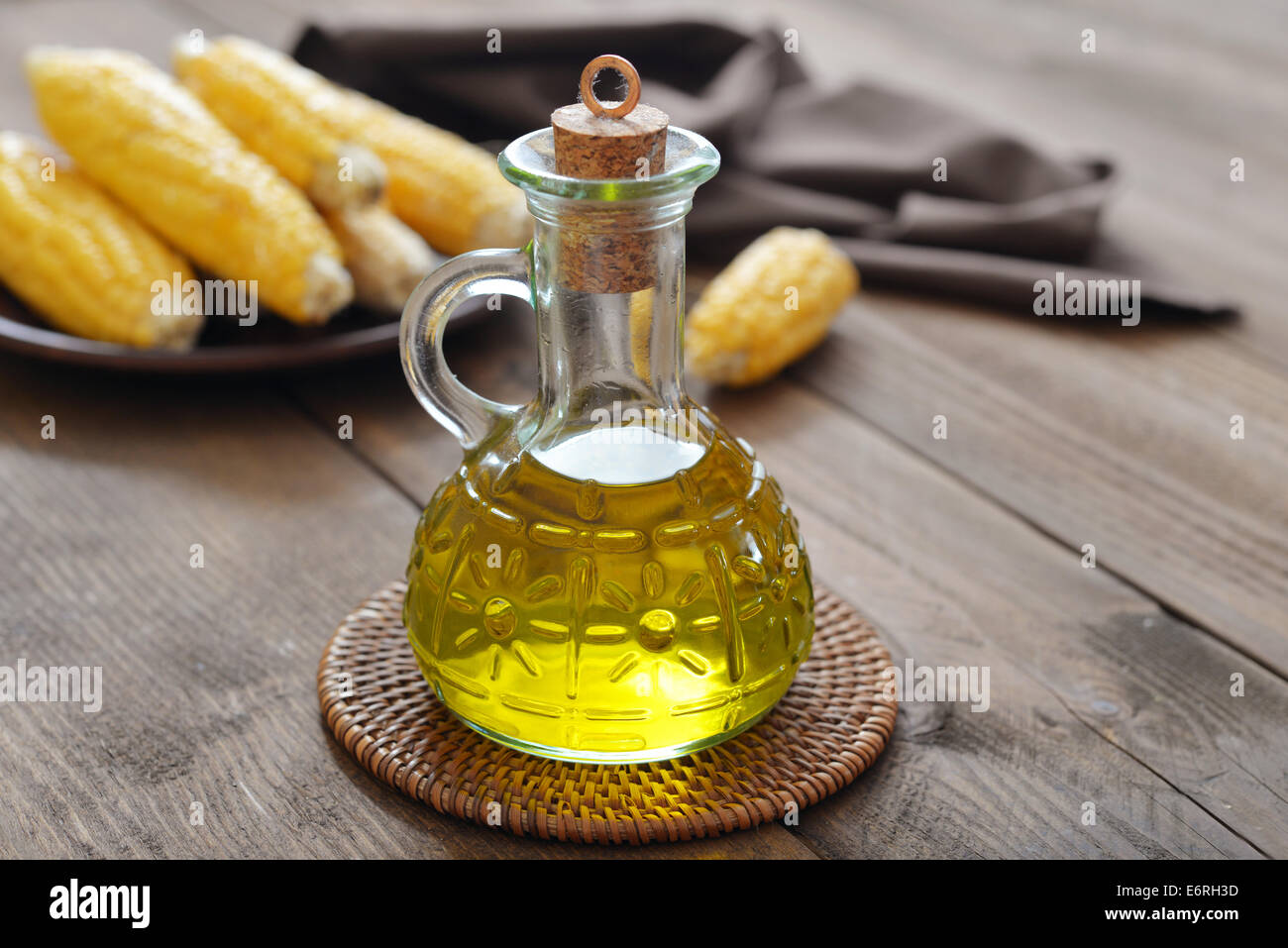 Corn oil in bottle with corn cobs on wooden background Stock Photo
