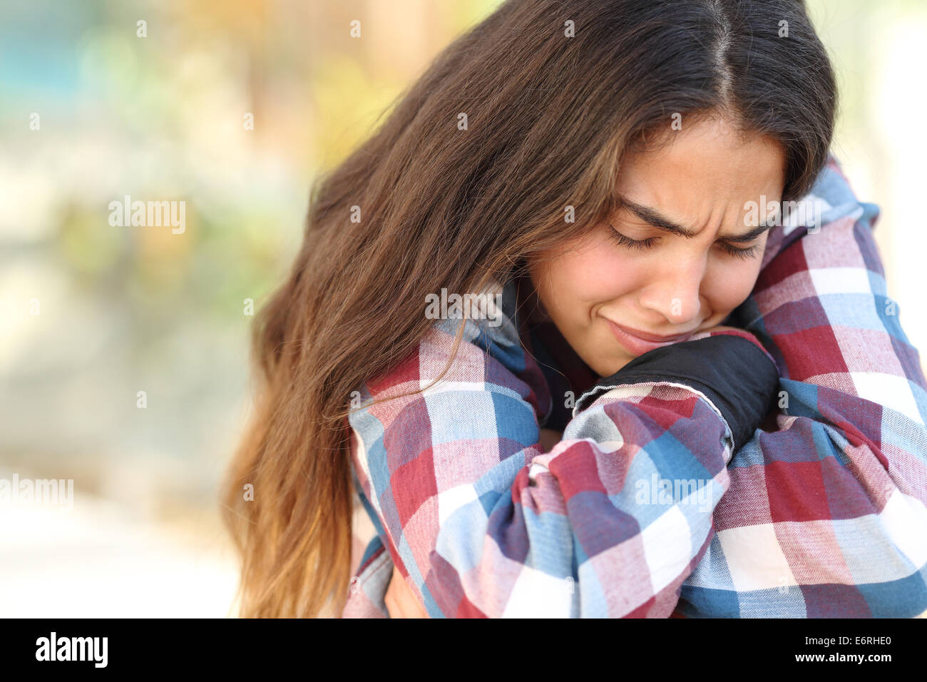 Close up of a teenager girl worried and sad crying outdoors Stock Photo