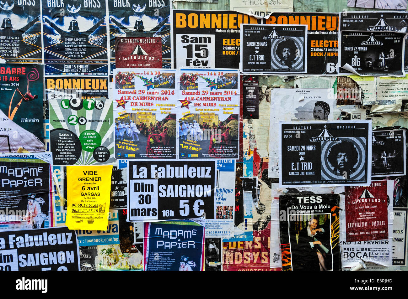 The shutters of an abandoned French shop, covered with posters advertising concerts and sales Stock Photo