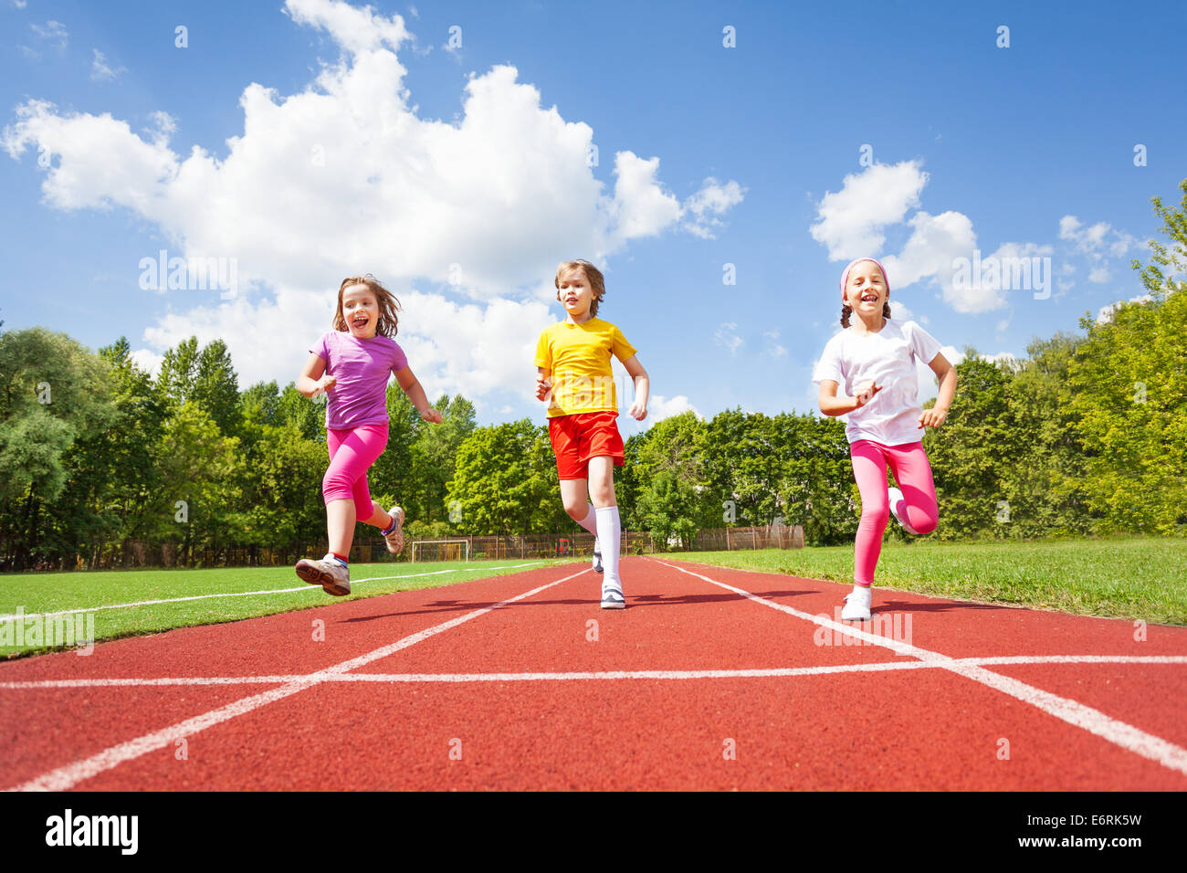 Smiling children running marathon together Stock Photo