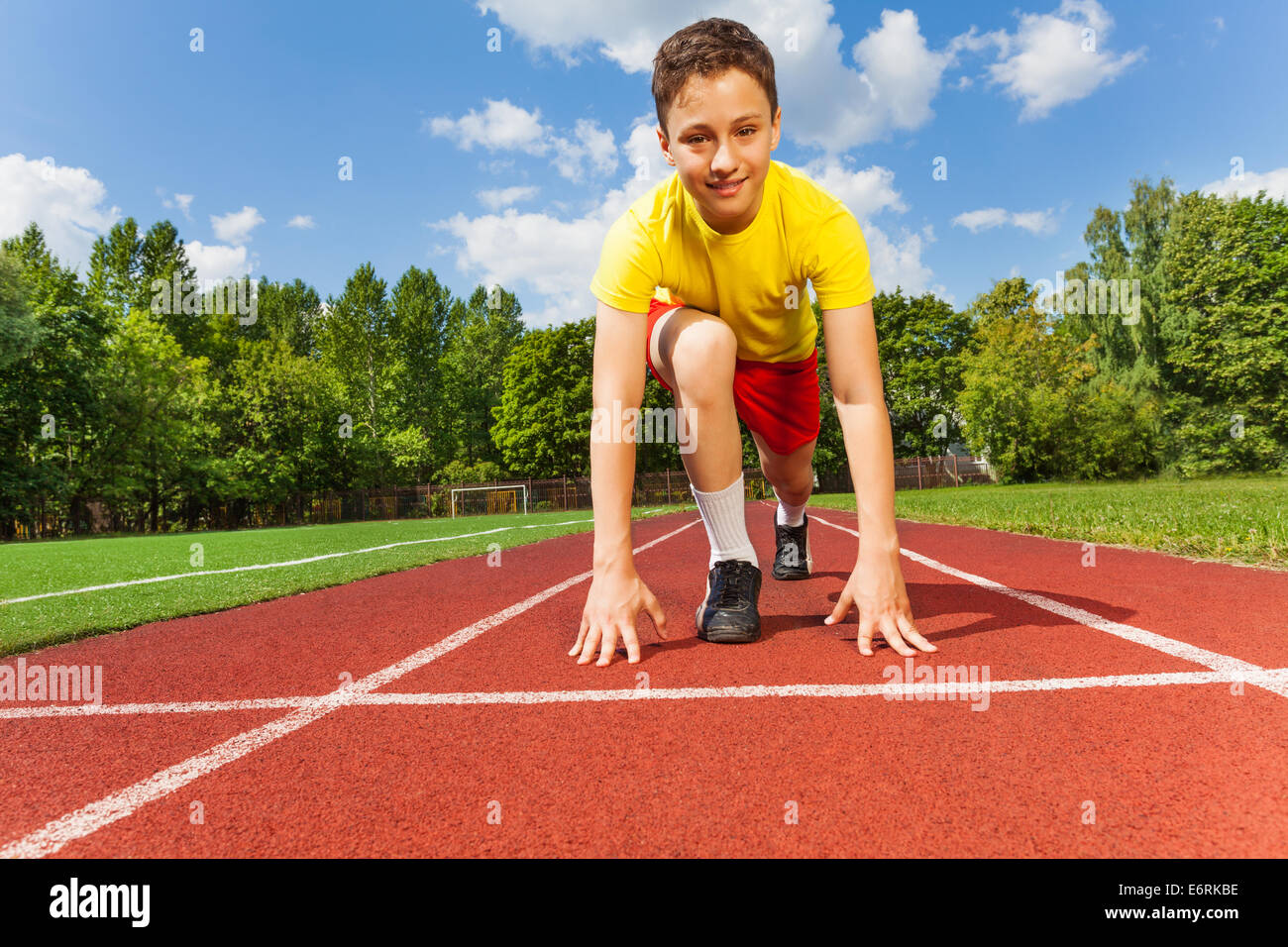 Boy in position to run with arms on the ground Stock Photo