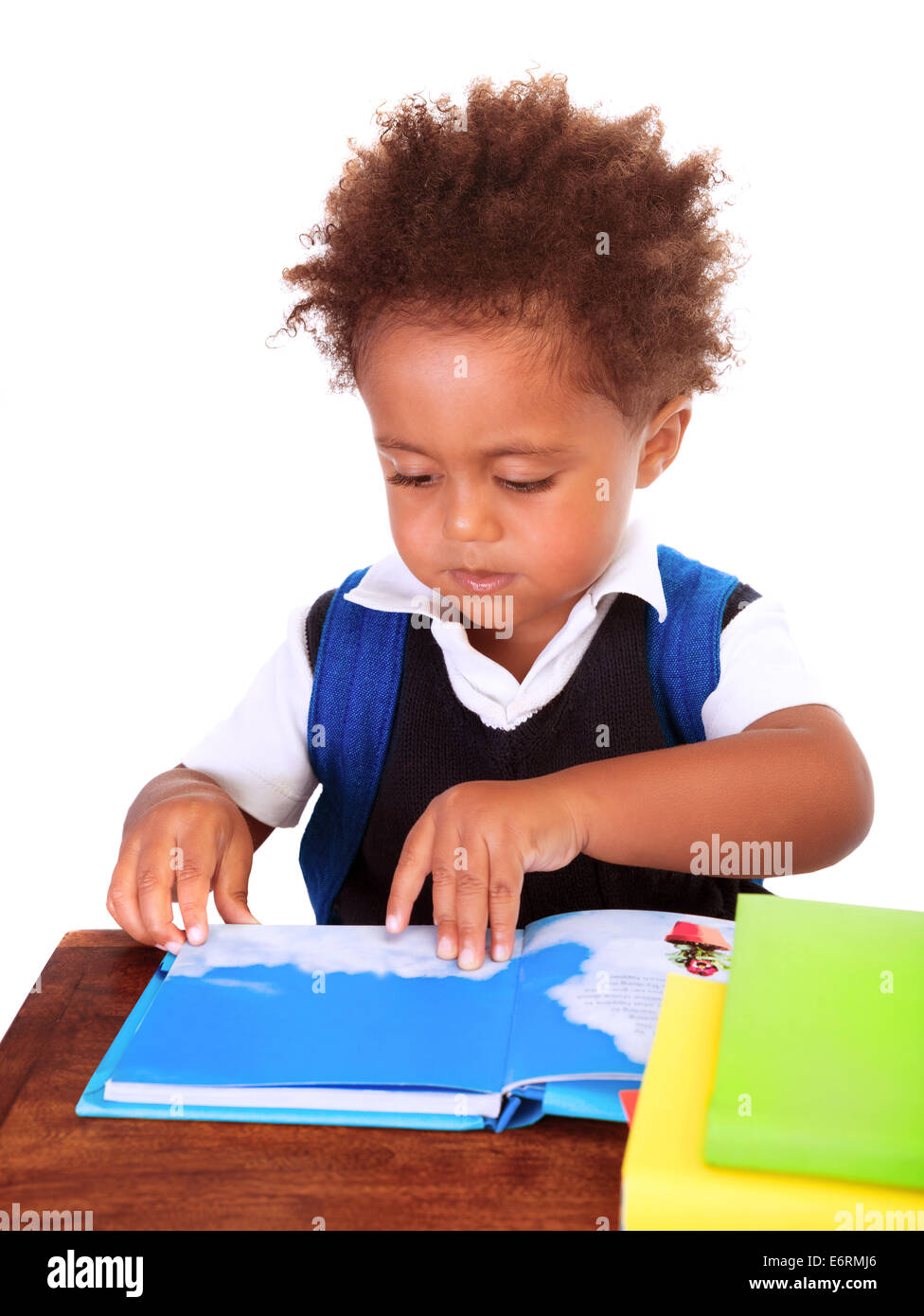Portrait of sweet little black boy reading books isolated on white background, preparation to go to first class, back to school Stock Photo