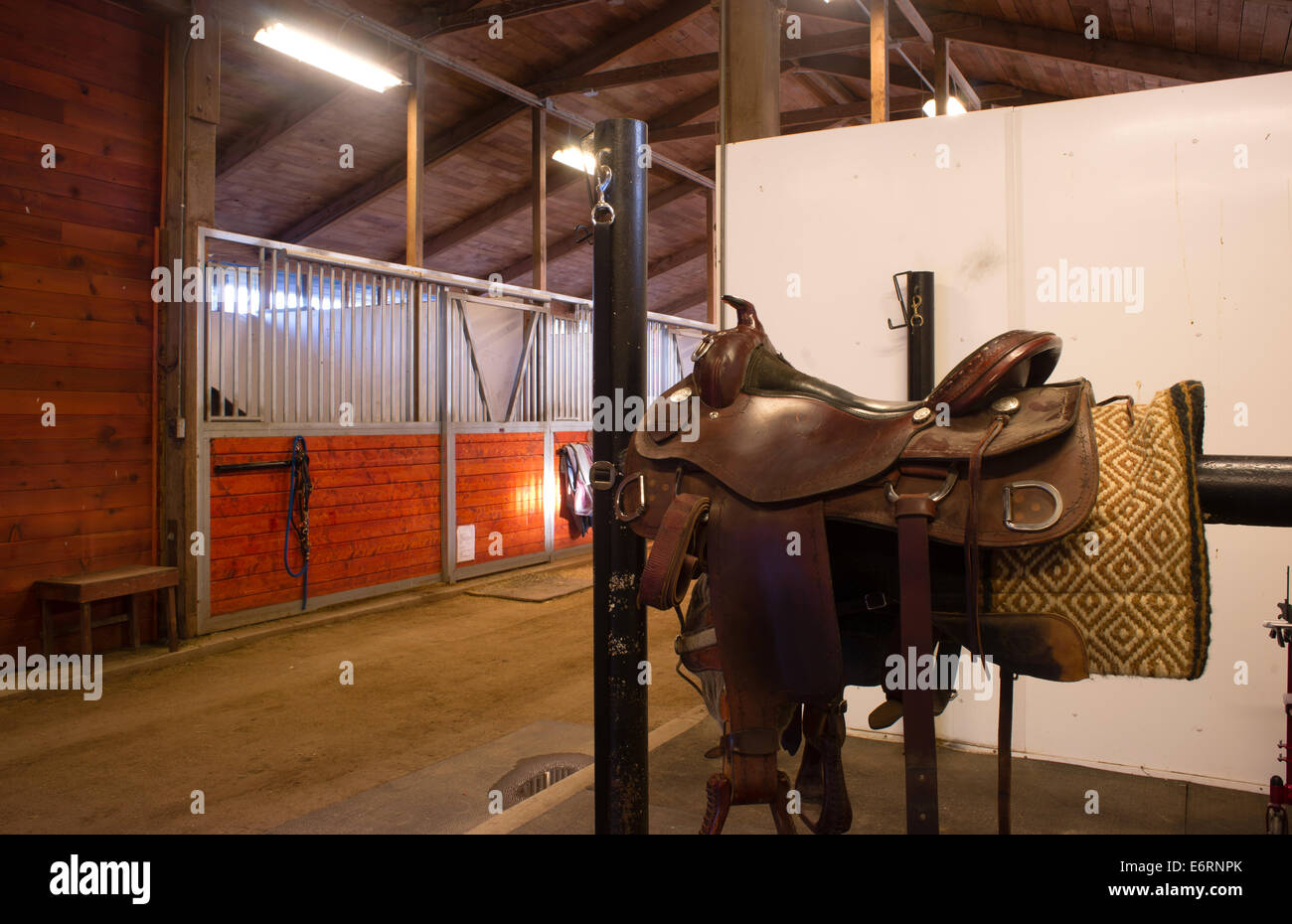 A saddle waits to be mounted on horses back at stables Stock Photo Alamy