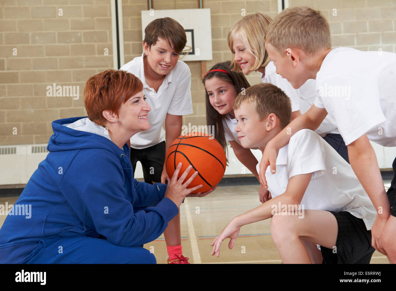 Coach Giving Team Talk To Elementary School Basketball Team Stock Photo