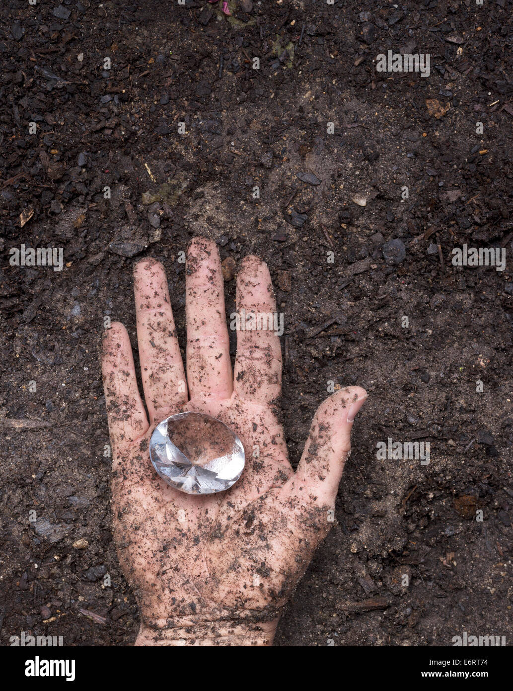 muddy dirty hand holding a glass diamond shaped Stock Photo