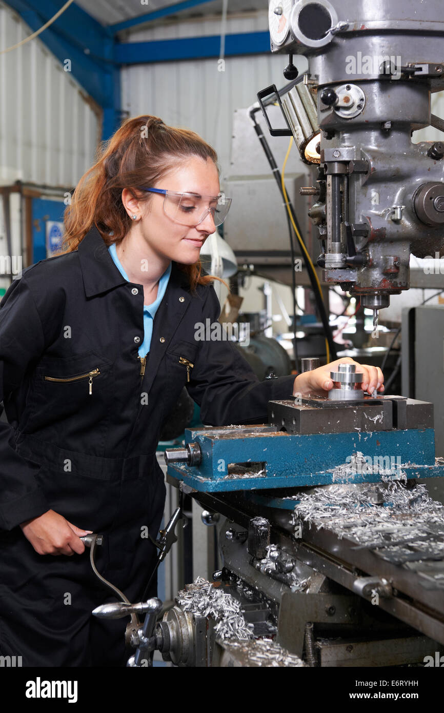 Female Apprentice Engineer Working On Drill In Factory Stock Photo