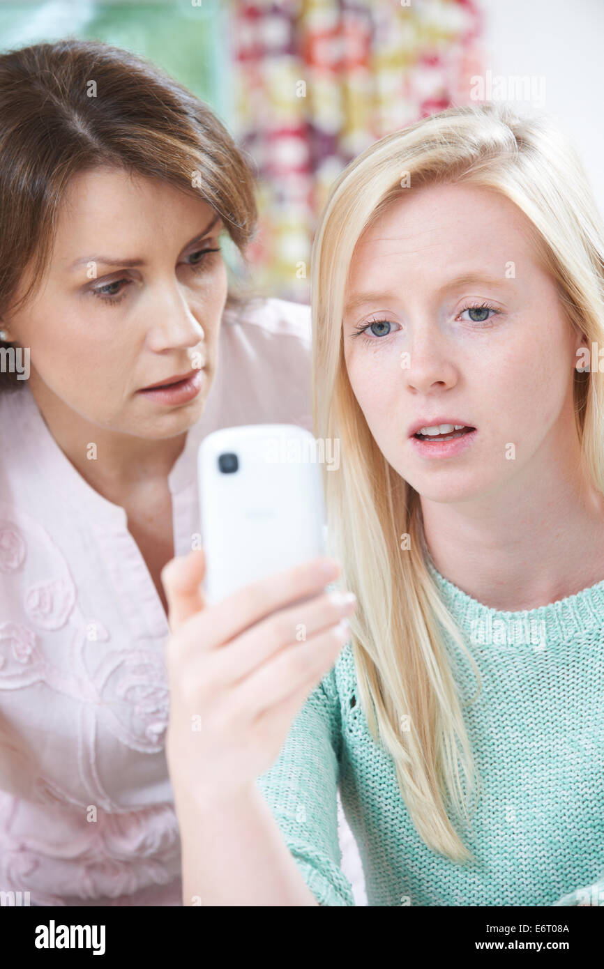 Mother Comforting Daughter Being Bullied By Text Message Stock Photo
