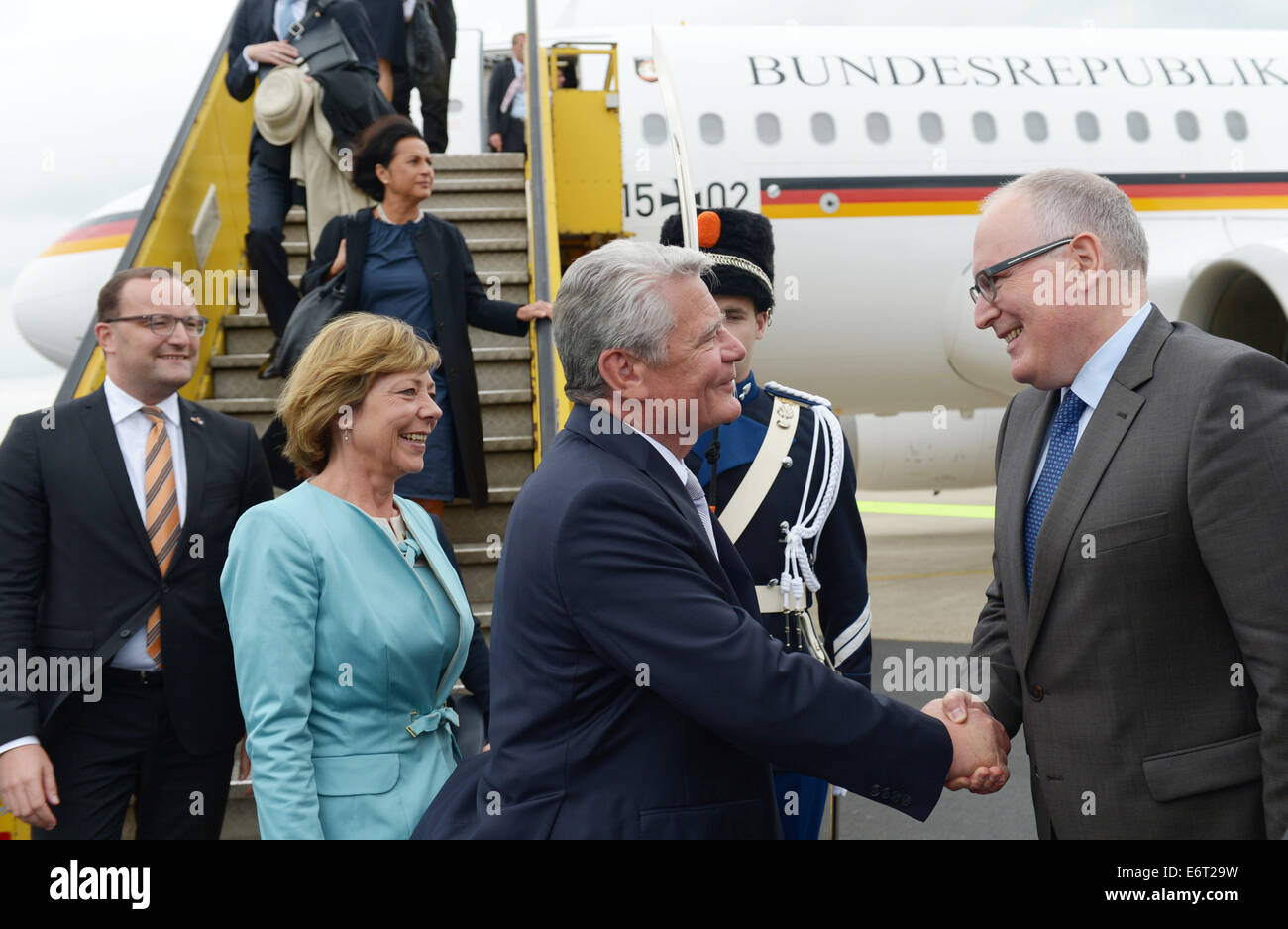Maastricht, Germany. 30th Aug, 2014. German President Joachim Gauck (C) and his partner Daniela Schadt alight from a government plane and are welcomed by Dutch Foreign Minister Frans Timmermanns at Maastricht-Aachen Airport in Maastricht, Germany, 30 August 2014. The attend the festivities on the occasion of the 200th jubilee of the Kingdom of the Netherlands. Photo: RAINER JENSEN/DPA/Alamy Live News Stock Photo